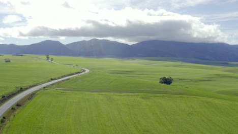 4k-drone-footage-of-a-car-travelling-along-a-road