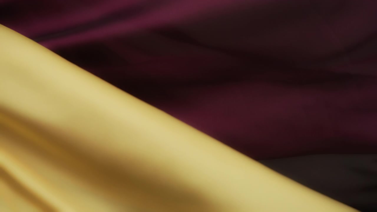 Tessuti setosi gialli e viola che ondeggiano al vento. Sfondo astratto con texture