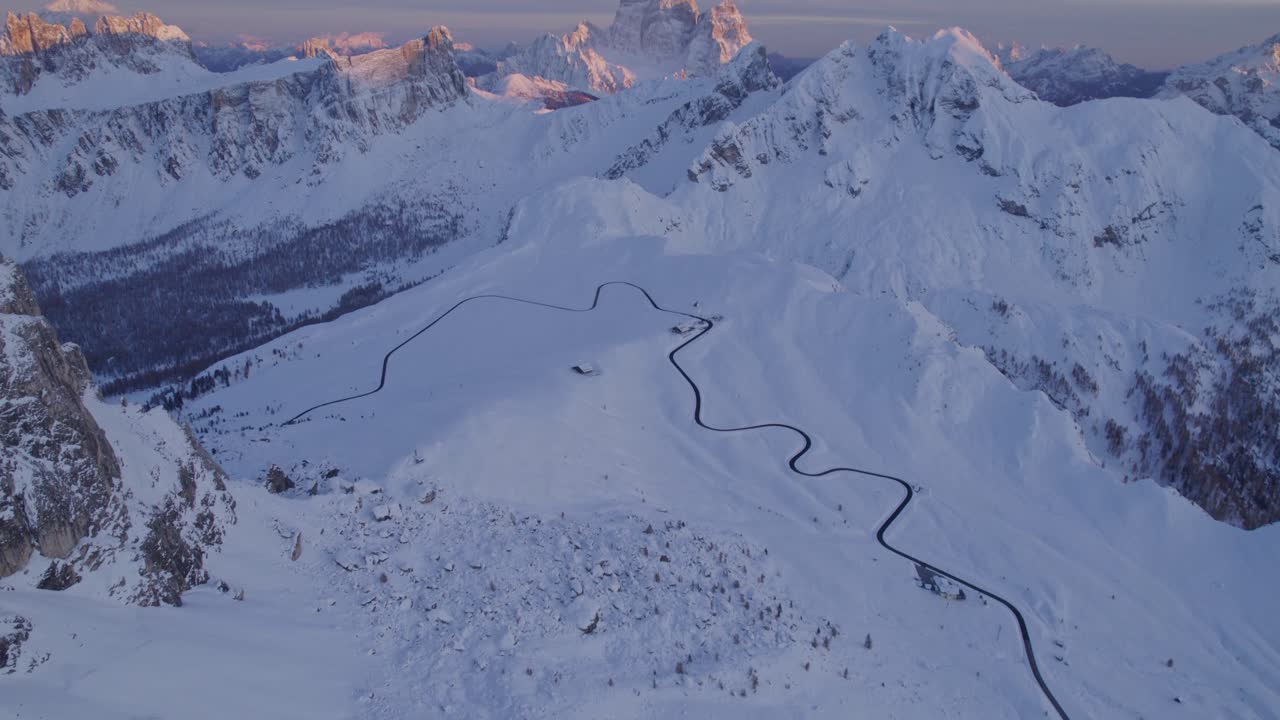 Sunset light illuminates snowy Dolomites, Passo di Giau, Italy