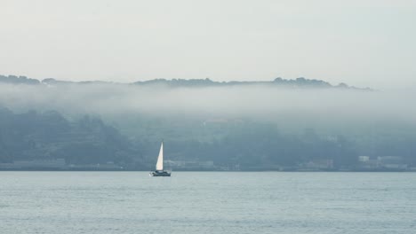 Segelboote-Mitten-Im-Blauen-Fluss-In-Nebliger-Szene,-Lissabon-Stadt,-Portugal