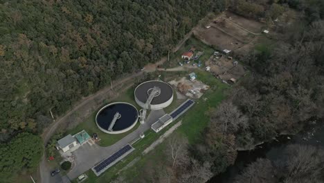 industrial water treatment facility with circular clarifiers, solar panels, and river landscape near amelie les bains palalda, revealing advanced environmental infrastructure in southern france