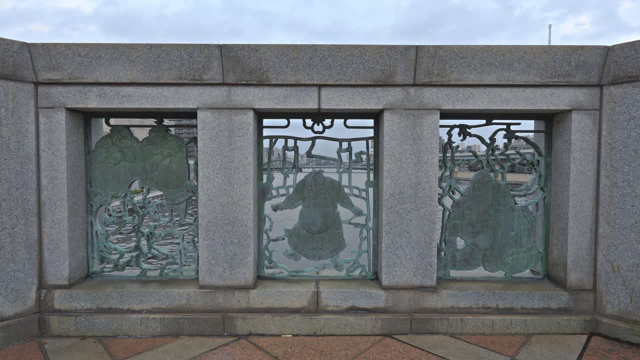 Detail of Kuramae Bridge's railing, featuring a unique metal relief depicting sumo wrestlers, a nod to Tokyo's rich cultural heritage.