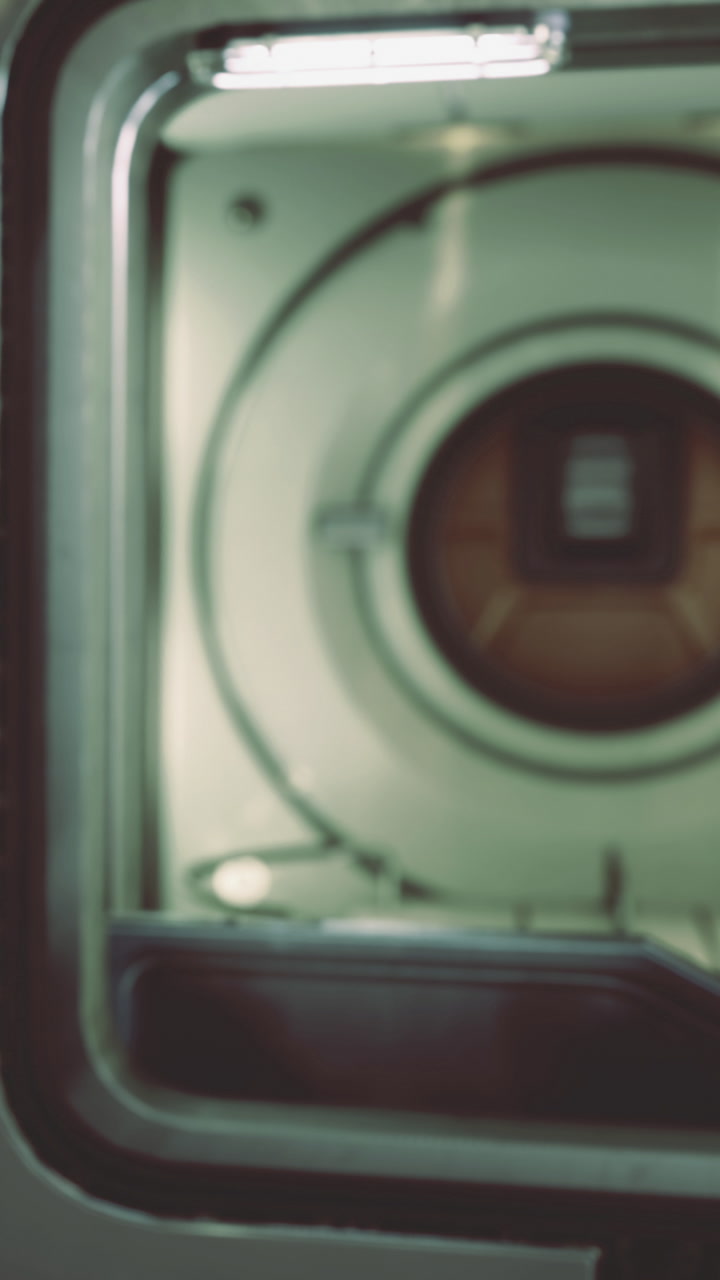 Close up view of a round lens inside an old camera in a dim room
