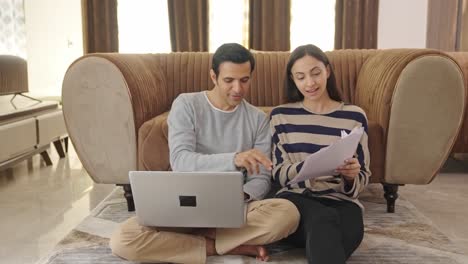 happy indian couple discussing and working together