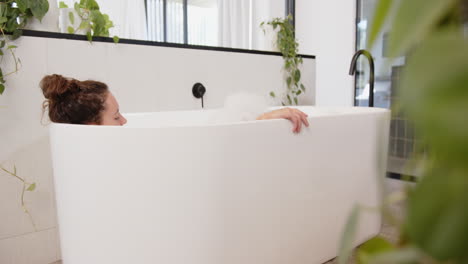 relaxing in bathtub, woman enjoying home day at home with plants around, copy space