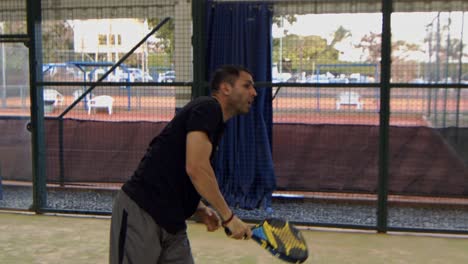 hombre latino jugando padel golpea la pelota en cámara lenta