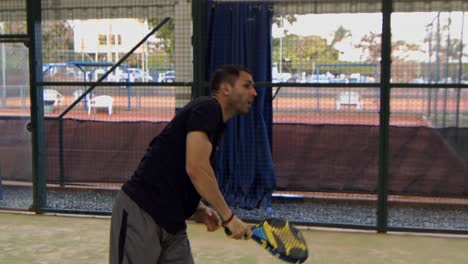 latino man playing padel slams the ball in slow motion