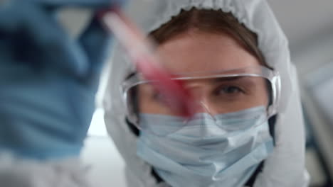 female scientist hand examining blood sample in test tube