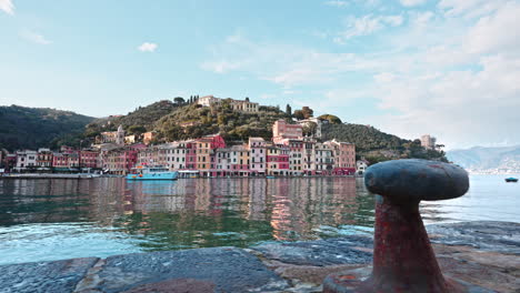 view from behind rusted bollard at harbor of portofino seaside vilage, italy
