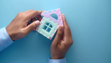 hands holding a colorful toy house