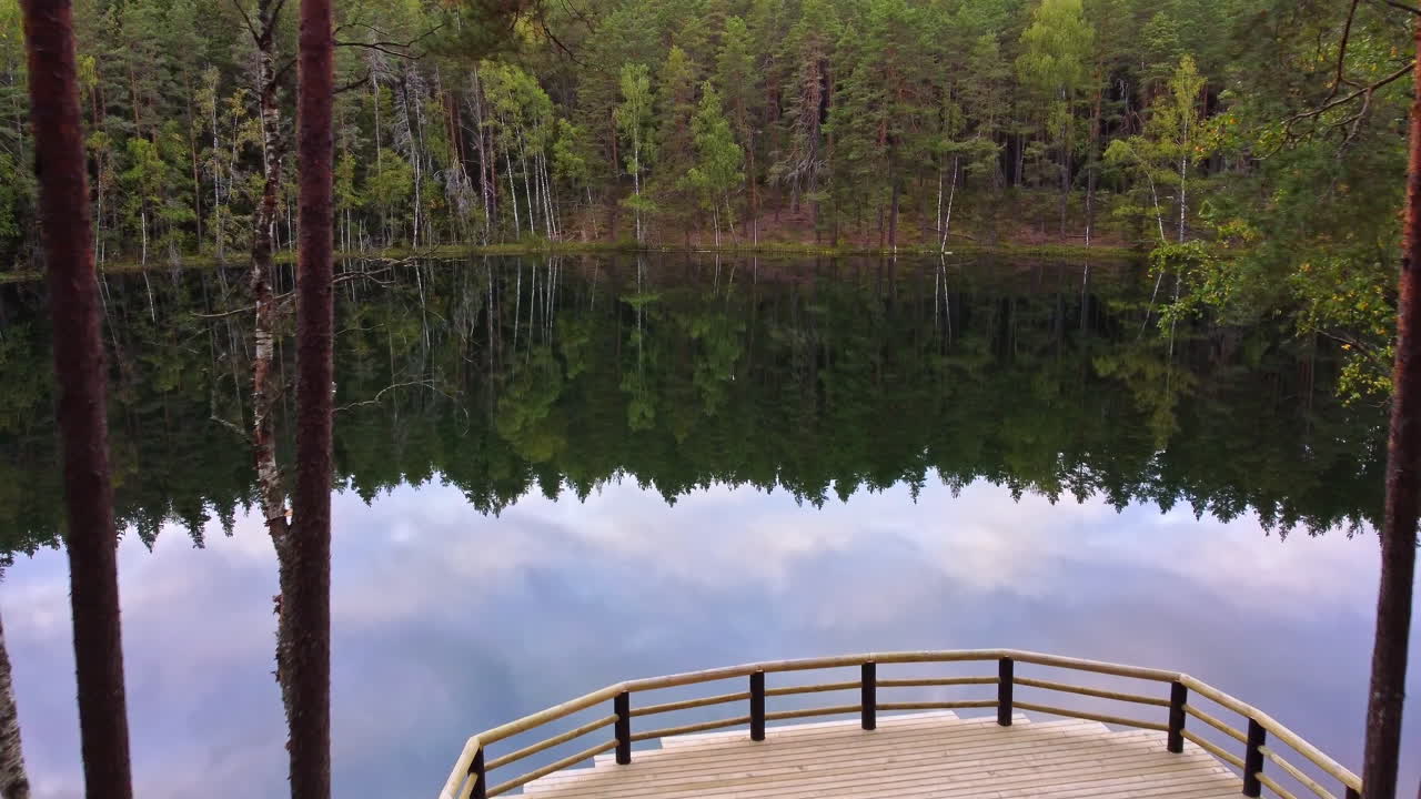 Wooden path leading to lake of Certoks Velnezers surrounded by dense forest
