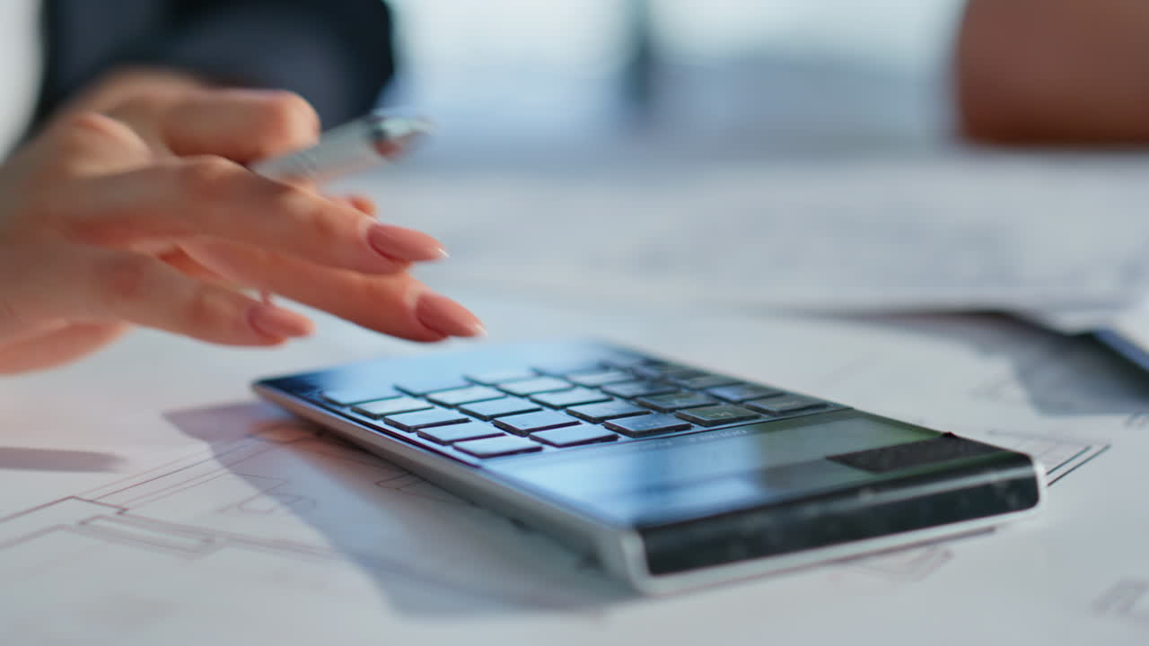 Woman hands calculating tax making paperwork at office using calculator closeup