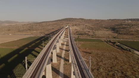 vía férrea en un puente sobre un valle que atraviesa el terreno de una colina en israel en otoño soleado