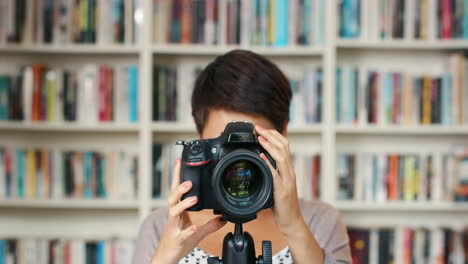 mujer tomando una foto en una biblioteca