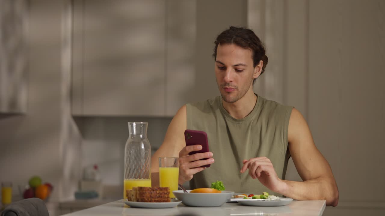 Man using phone during breakfast at home