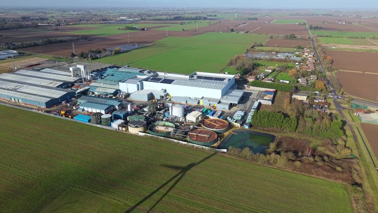 Top down aerial view capturing the circular patterns of industrial liquid storage silos and factory piping