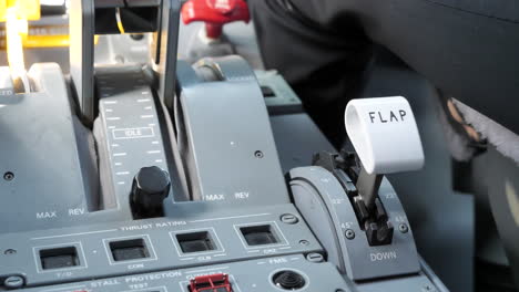 pilot in the cockpit setting flap lever of an airplane into 22 degrees