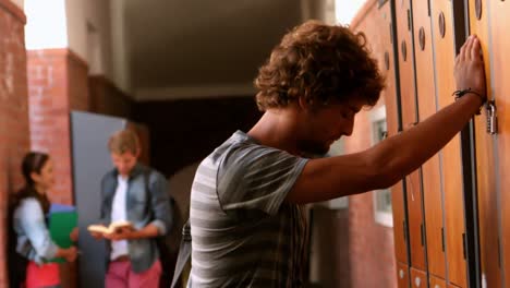 overwhelmed student leaning against locker