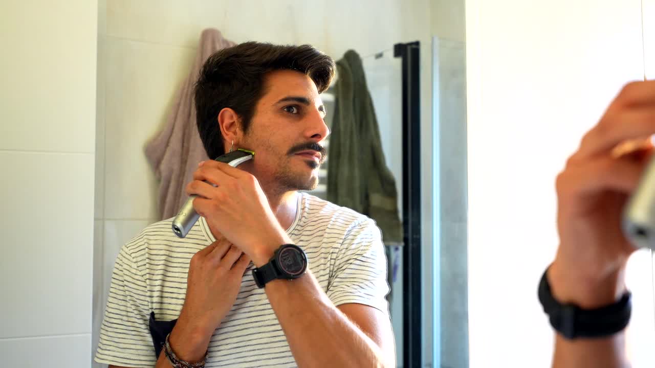 Man Trimming Facial Hair in Bathroom Mirror
