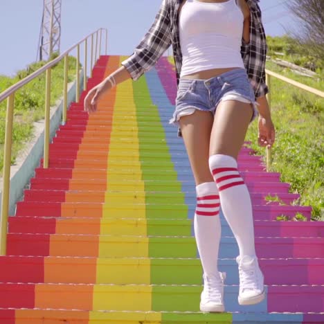 young woman walks down the colorful stairs