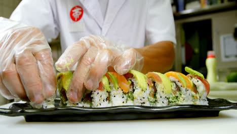 chef masculino arreglando sushi en una bandeja en la cocina 4k