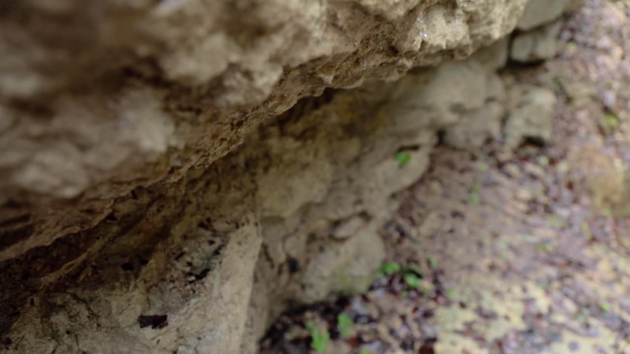 L'acqua gocciola dalla roccia al rallentatore con zoom in 4k.
