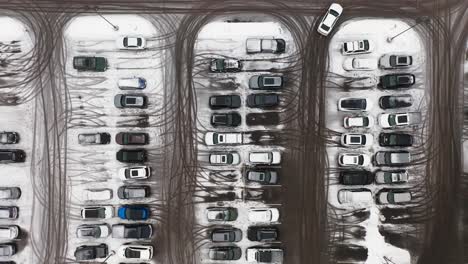 aerial top down, cars parked in snowy parking lot during winter season