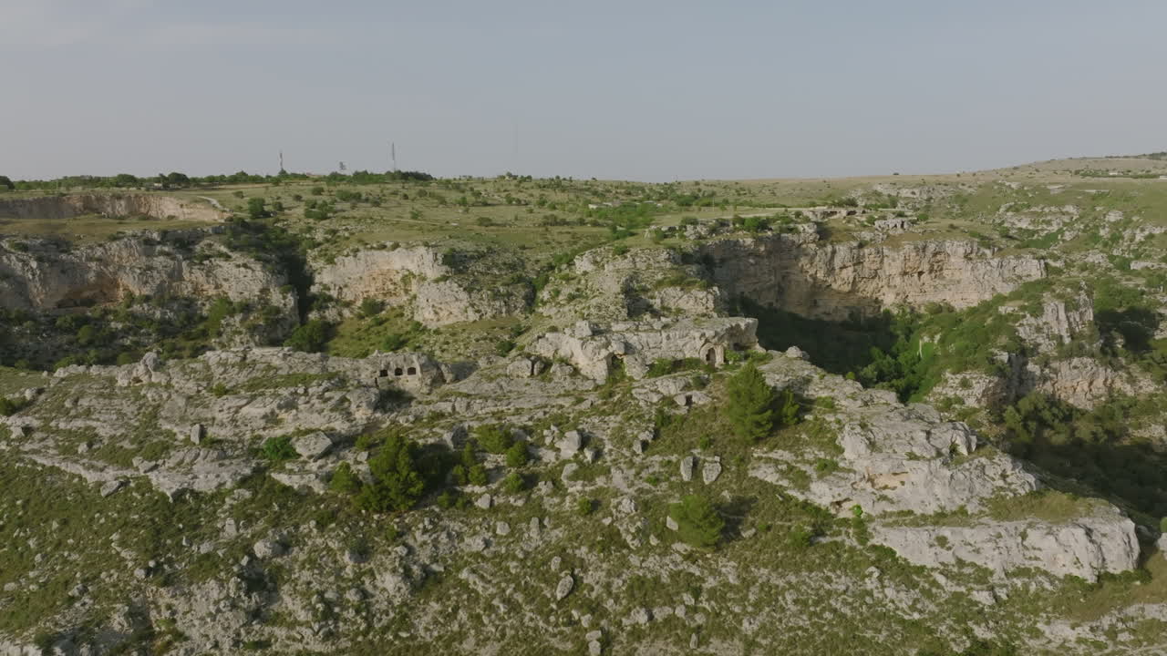 sobrevuelo aéreo del cañón y cuevas frente a la ciudad de matera en italia durante la luz del atardecer