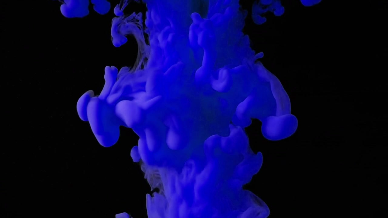 Inchiostro blu che cade e si avvolge nell'acqua su sfondo nero