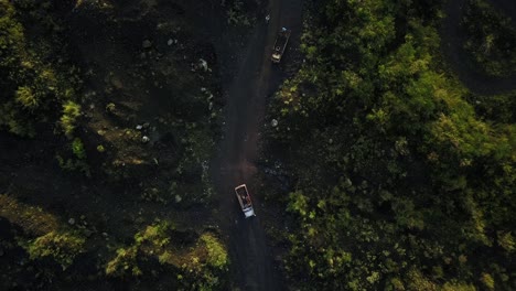 aerial top down shot of trucks transporting sand of sand mine between destroyed rainforest