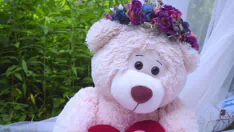 oso de peluche en tela blanca en el parque. primer plano del oso de peluche en el fondo de hierba