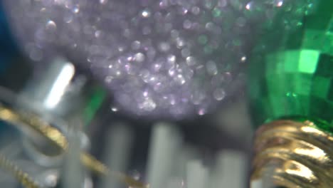decoración de navidad, coloridos adornos de cristal partículas borrosas, bolas coloridas en un soporte giratorio 360 año nuevo decorado, luces brillantes, cinematográfico primer plano macro inclinación hacia abajo video 4k, profundidad de campo