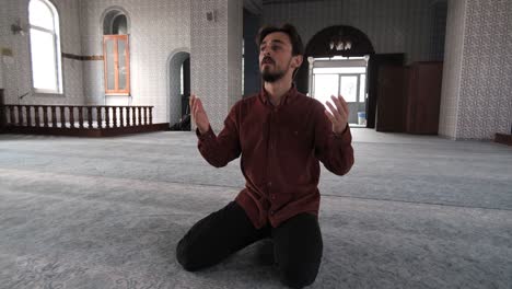 man sit and praying in mosque