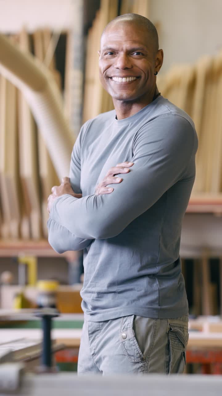 Uomo afroamericano sorridente con le braccia incrociate in un laboratorio.