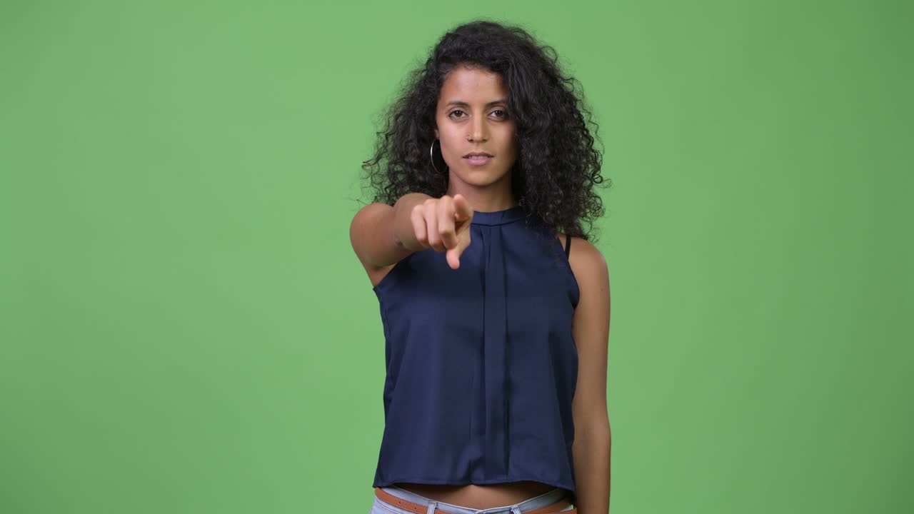 Young beautiful Hispanic businesswoman pointing at camera