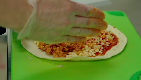 cu cocinero en cámara lenta prepara el kebab pone los ingredientes - pollo frito queso mayonesa