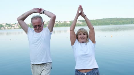 elderly couple exercising by the lake
