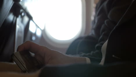 man watching movie on smart phone in plane