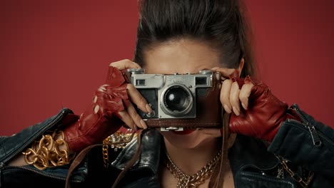 woman in 1980s fashion posing with vintage camera