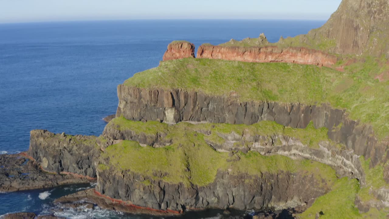 Aerial slow motion scan capturing the beauty of the Giant’s Causeway coast, cliffs and rock formations