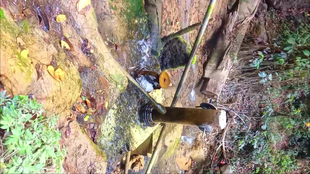 una antigua bomba de agua holandesa cerca de una fuente de agua