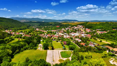 scenic village under blue sky. a scenic view of a quaint village nestled among lush green hills on a sunny day