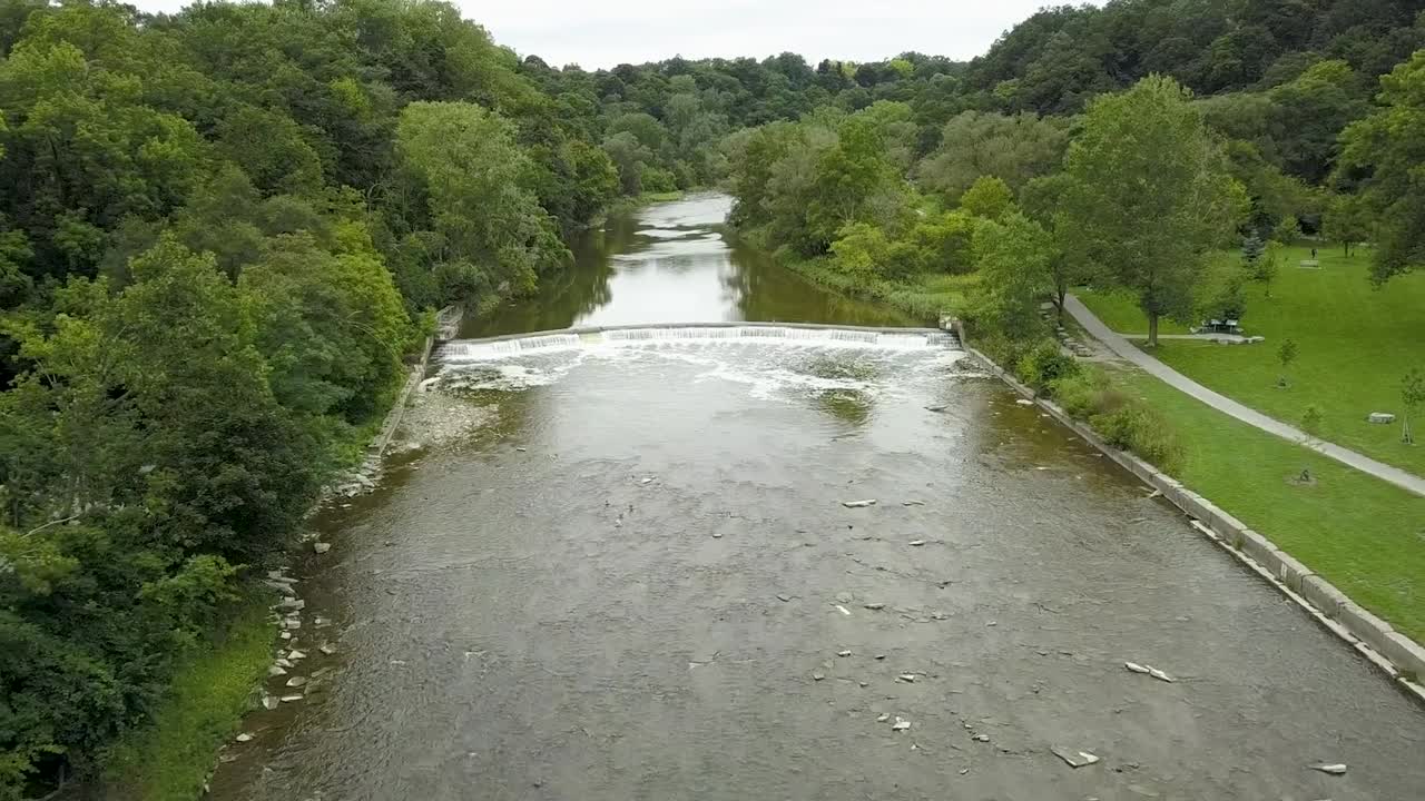 Drone flyver op ad en flod med et lille vandfald i Toronto