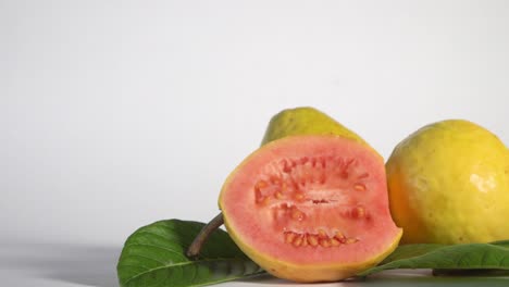 Panning-close-up-of-fresh-red-guava-fruit-isolated-on-white-background