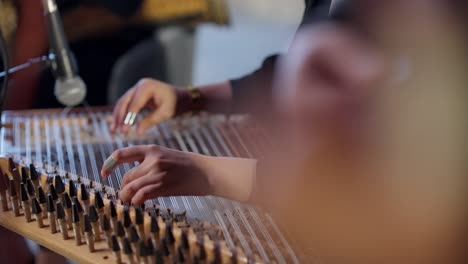 a woman playing on zither in the theatre beside a man playing oud high angle shot, close up