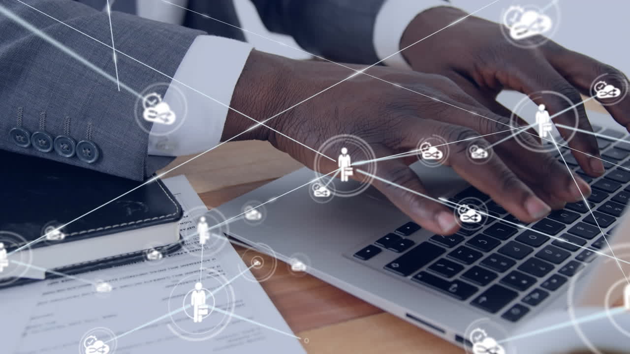 Animation of network of icons over african american businessman using laptop