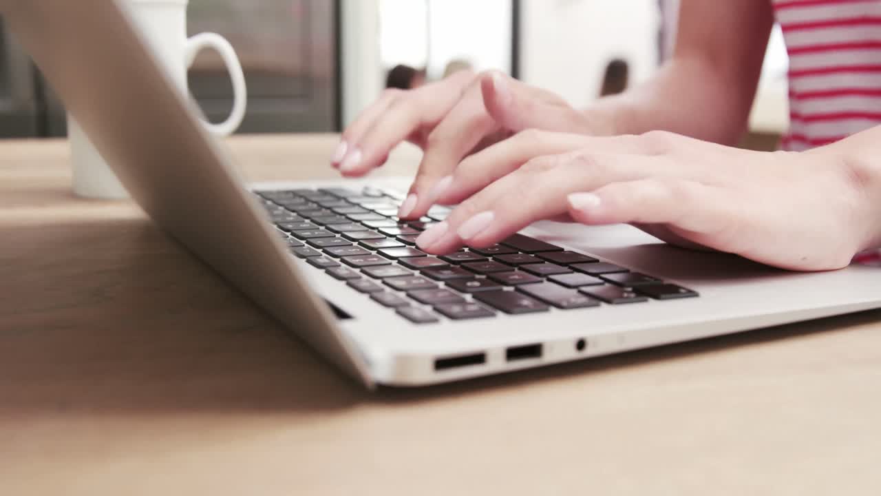 Close up view of a woman typing on her laptop