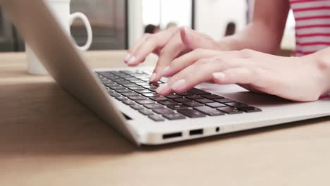 close up view of a woman typing on her laptop