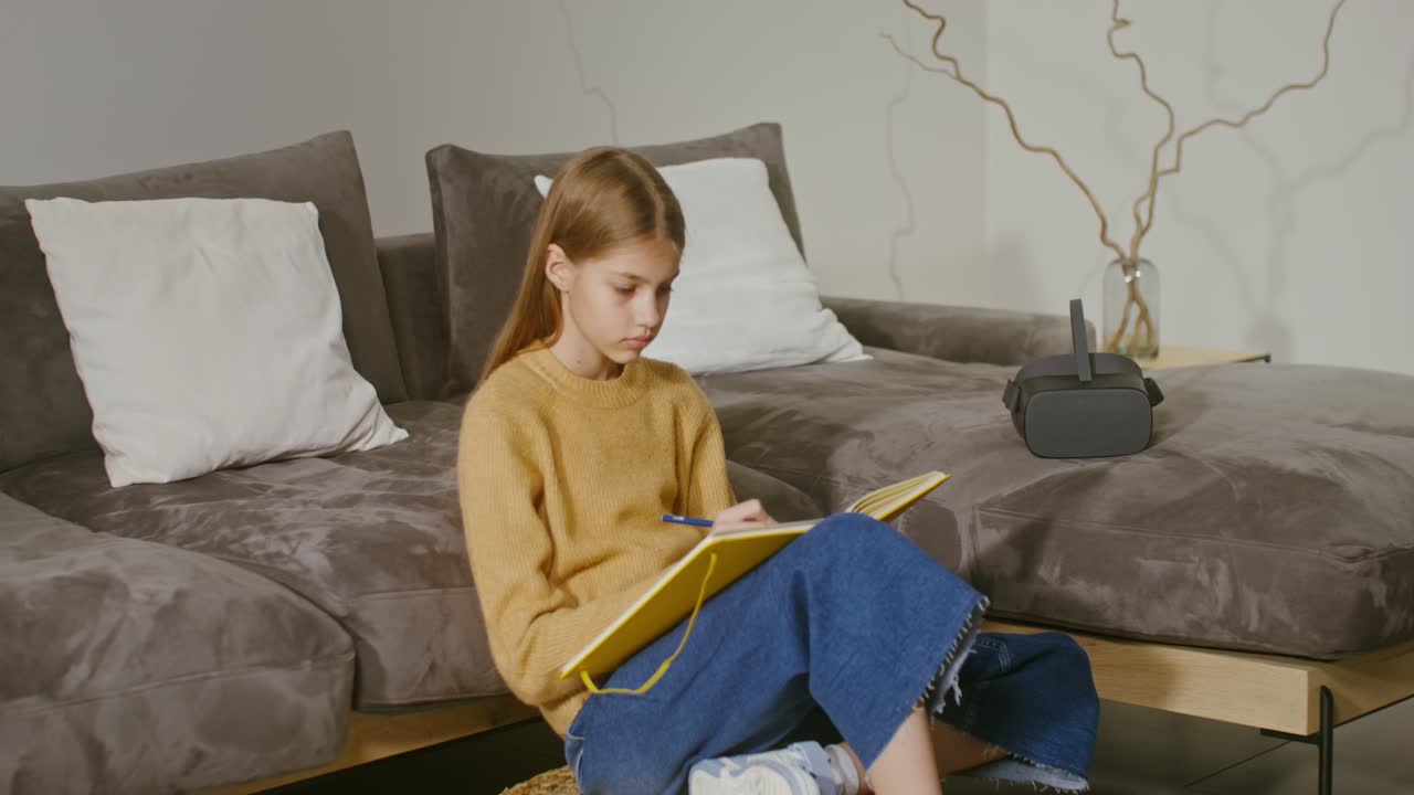 십대 소녀가 vr 헤드으로 집에서 공부하고 있습니다.