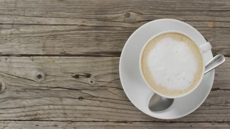 video de una taza blanca de café con leche sobre un fondo de madera